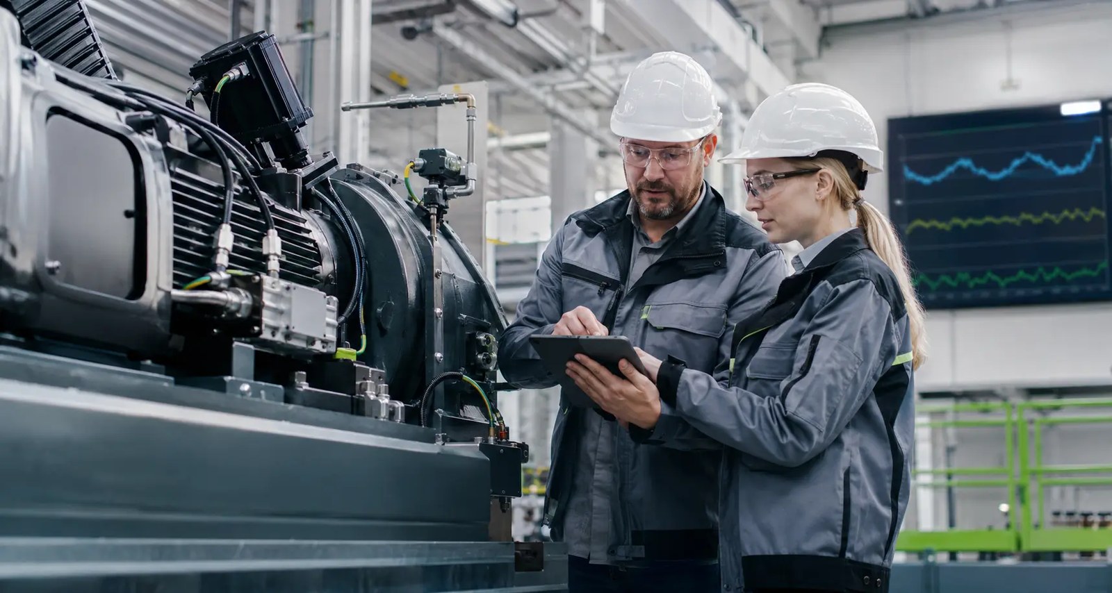 Dos profesionales analizan con una tableta el rendimiento de un activo industrial monitorizado con inteligencia artificial